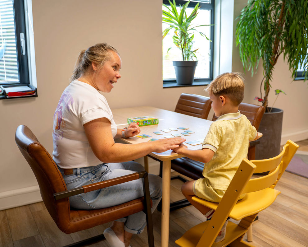 Ouders in gesprek met een behandelaar aan tafel